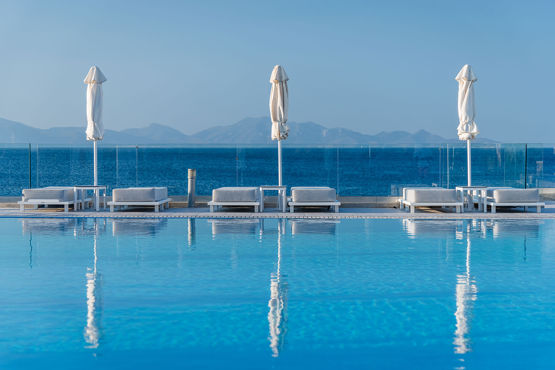 
Pool and sunbeds with closed umbrellas